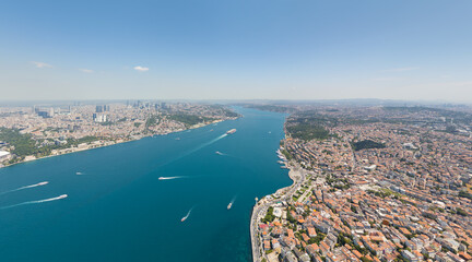 Istanbul, Turkey. Bosphorus Bridge with oil tanker and busy ferry traffic near Uskudar Ferry Terminal. Asian shore, intercontinental connection and maritime transport at summer midday. Aerial view.