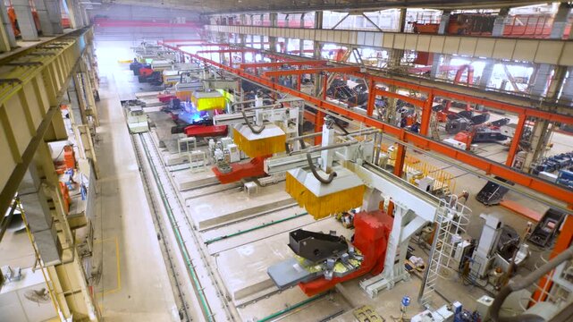 Large Factory Manufacturing Floor with Industrial Equipment and Overhead Cranes