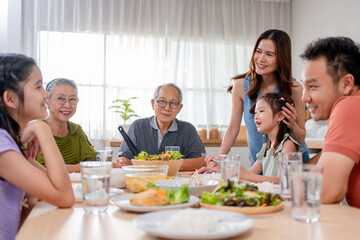 Asian loving family spending quality time, having dinner in cozy house. 