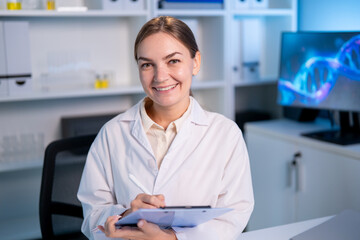 Portrait of Caucasian female scientist in white lab coat in laboratory.