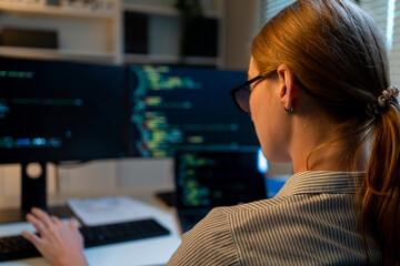 Close up of young female software engineer working at night in office.
