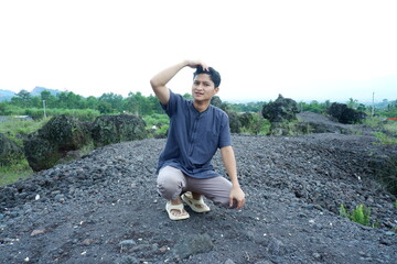 Natural Candid Man Touching Head on Volcanic Rock Landscape