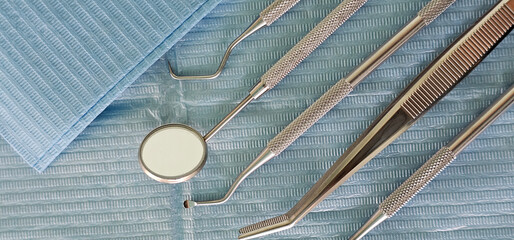 Pile of dentist tools lying at green tissue ready to be used