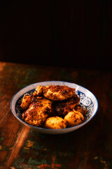 Fried chicken breast with potatoes. Rustic wooden background. Soft focus.	