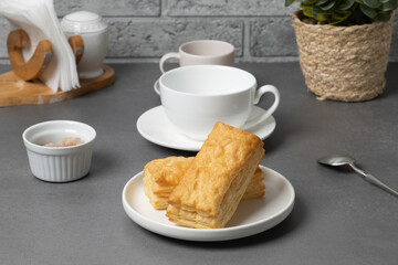 Freshly baked pastries with tea set on a simple table in a cozy cafe setting