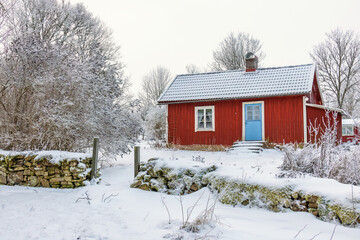 Idyllic red cottage in a wintry landscape
