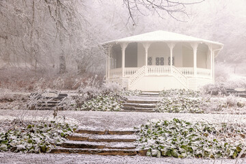 Pavilion in a garden with frost in a park at winter