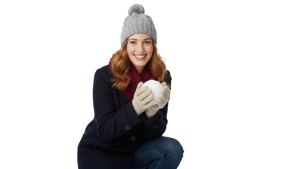 Joyful woman holding snowball for playful winter fun, smiling in cozy hat and scarf outdoors