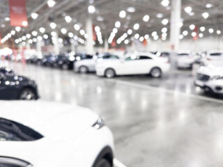 Blurred background with car dealership store interior. Blurred abstract dealership store with defocused cars. Blur bokeh transportation concept dealer showroom