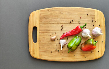 Pepper, chili, and garlic on a wooden surface. Top view.