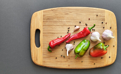 Composition of pepper, chili, garlic, on a wooden surface.