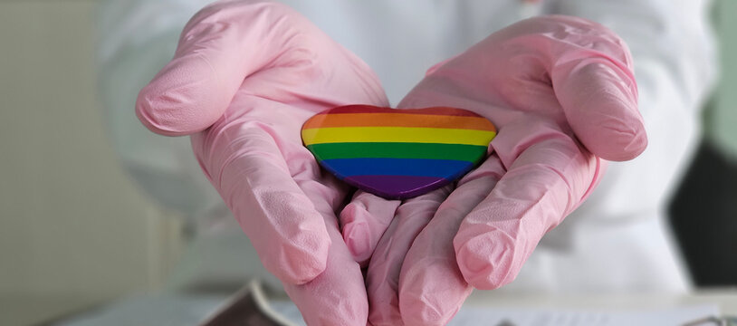 Health care lgbt and doctor holding lgbt badge. Treatment and rights for transgender and gay people concept - Powered by Adobe