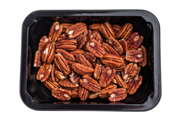 Raw pecan halves packed in a black plastic container on a clean white background creating a simple ingredient image ideal for culinary stock themes