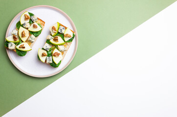 Bruschetta with spinach, honey, blue cheese, pear, and nuts. Healthy eating. Vegetarian food.