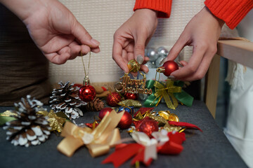 Christmas Crafting. Women decorating with ornaments and gifts during festive holiday preparations.