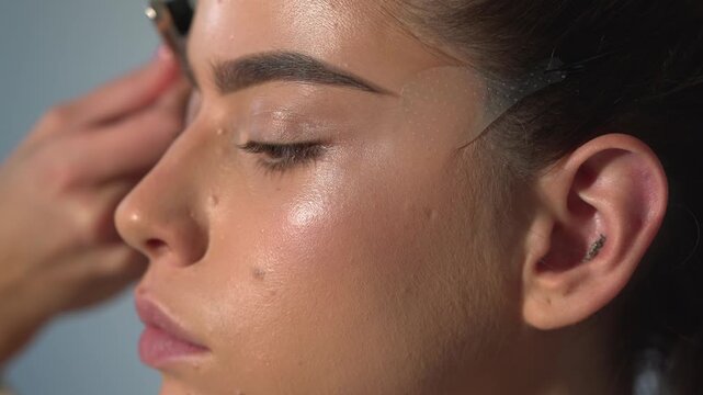 Fashion make-up fot young sexy woman. Close up visage, cosmetic, mascara. Makeup artist applying foundation skin, blusher and powder. Beautiful woman face. Beauty sensual girl with perfect skin.