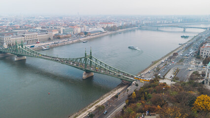 Naklejka premium Liberty Bridge in Budapest, Hungary, spanning the Danube River on a foggy autumn day.