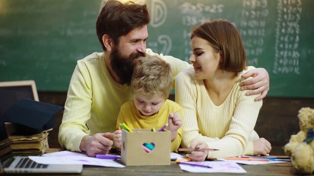 Schoolboy and parents studying. Family school and kids home schooling. Education family and homework concept, happy father mother and son writing to notebook at home class.