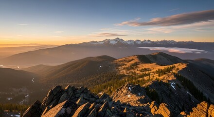 sunrise over snowy peaks with jagged rocks forested ridges and pastel sky in tranquil mountain scene