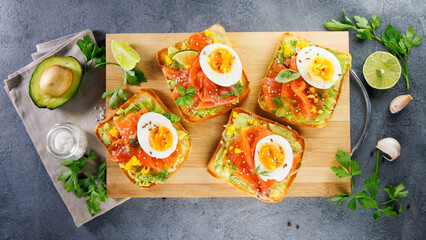 bread toast with avocado, smoked salmon and egg. breakfast or brunch protein toast