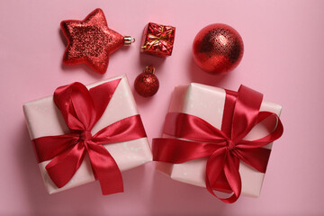 Top view of Christmas gifts with decorations on pink background
