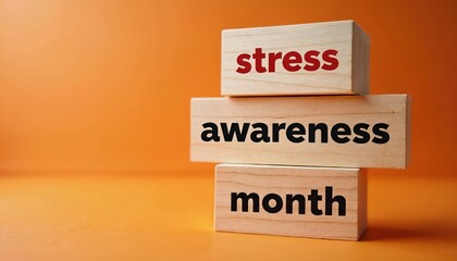Image shows wooden blocks with text. The blocks spell Stress awareness month. It is a photo on an orange background. Concept of mental health awareness