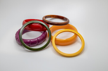 Close up studio shot of various color vintage bakelite bangle bracelets on white background, with copy space