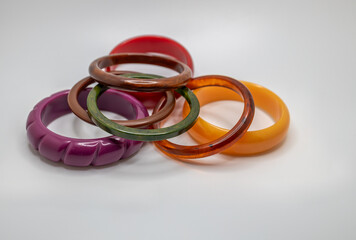 Close up studio shot of various color vintage bakelite bangle bracelets on white background, with copy space