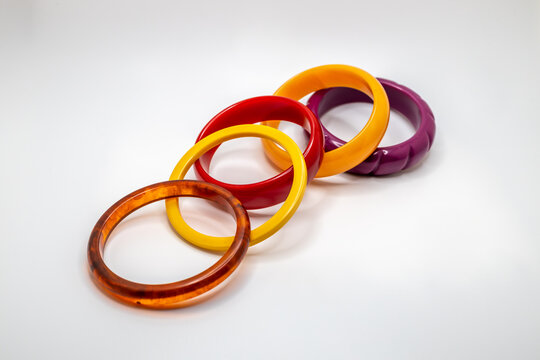 Close up studio shot of various color vintage bakelite bangle bracelets on white background, with copy space - Powered by Adobe