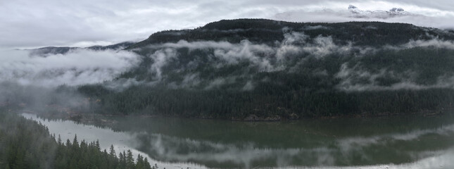 Misty Mountain Lake With Fog Over Forested Peaks and Reflections in British Columbia, Canada