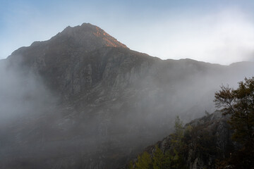 Morning mist rising around a rocky Snowdonia mountain ridge