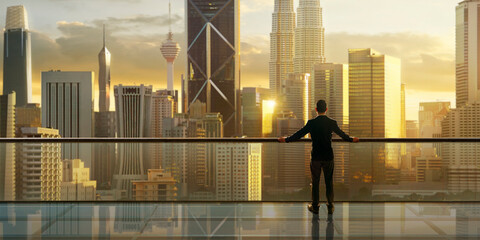 Businessman enjoying cityscape view at golden hour sunrise
