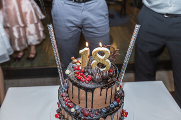 Elegant chocolate birthday cake with berries and sparkler candles for 18th celebration