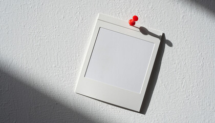 blank white instant photo frame with shadow pinned to the wall with red pushpin isolated on white or transparent
