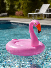 Pink flamingo pool float in a sunny swimming pool.