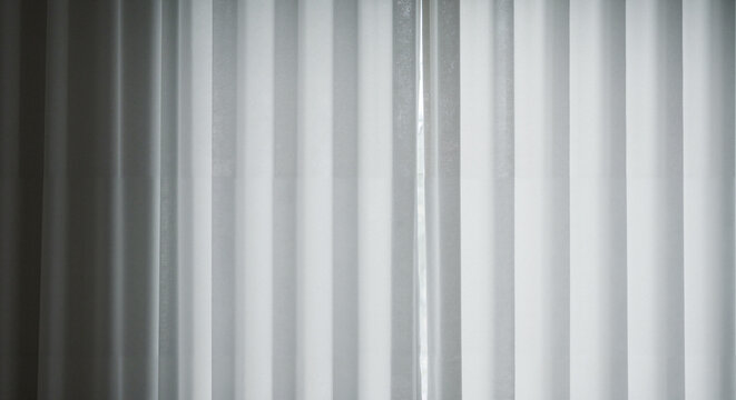 Sheer white curtains gently hanging indoors in natural light  
