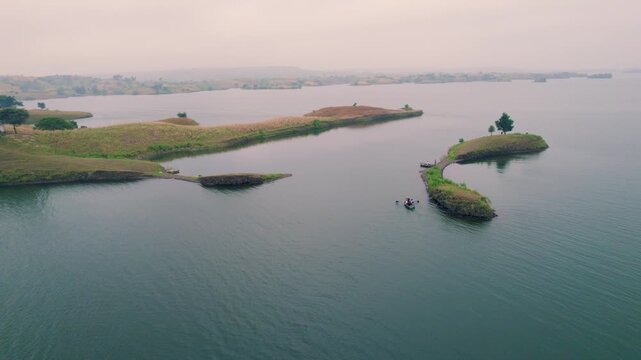 Aerial drone view of Banswara lakes and islands near Udaipur, Rajasthan, India, captured during a breathtaking sunrise, showcasing a cinematic blend of natural beauty with a boat moving across the wat