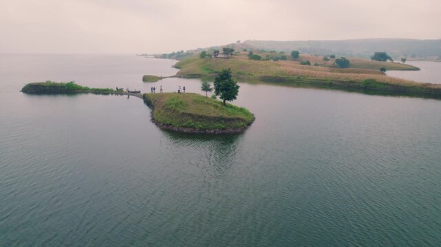 Aerial drone view of Banswara lakes and islands near Udaipur, Rajasthan, India, captured during a breathtaking sunrise, showcasing a cinematic blend of natural beauty with a boat moving across the wat