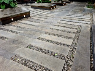 Stone walkway outdoors, natural stepping path with gravel and flat stones creating rustic pedestrian design