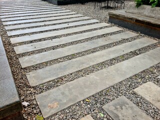 Stone walkway outdoors, natural stepping path with gravel and flat stones creating rustic pedestrian design