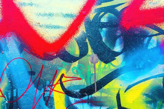 Dynamic graffiti pattern in vibrant neon red, blue, yellow. Urban 90s style, bold texture, fluorescent glow. Street art, backgrounds, posters, modern 90s, Y2K creative banner. - Powered by Adobe
