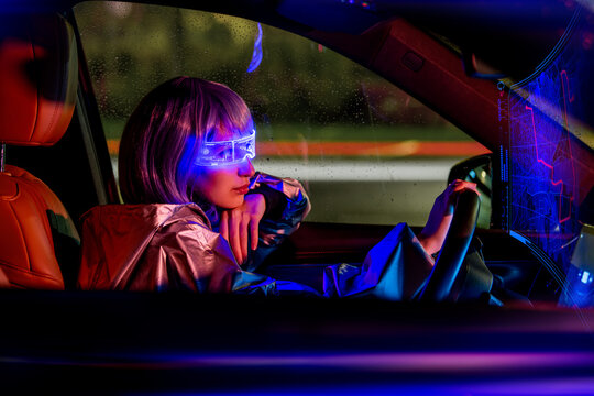 young woman driving car at night wearing futuristic AR glasses