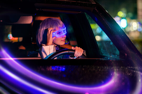 young woman driving car at night wearing futuristic AR glasses