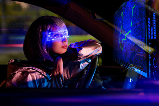 young woman driving car at night wearing futuristic AR glasses