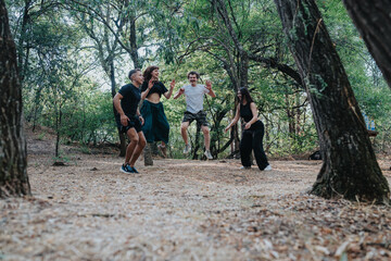 Fototapeta premium A group of friends jumps and plays on a forest trail, enjoying outdoor fitness, energy, and camaraderie in a natural park setting.