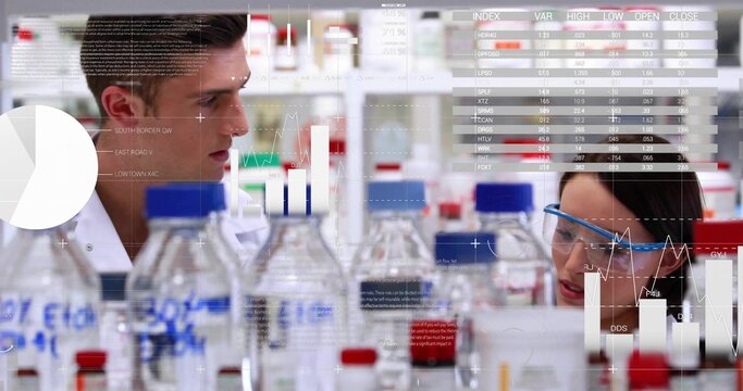 Two researchers in white lab coats discussing data at lab bench, with reagent bottles and goggles