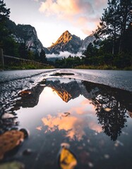A stunning landscape photograph showcasing a dramatic mountain range illuminated by warm sunset light