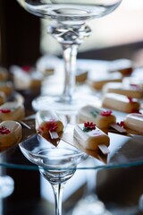 Elegant mini desserts on glass stand at wedding reception