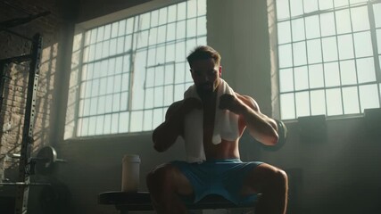 Muscular man drinking protein shake after intense workout at gritty industrial gym, 4k high quality footage - Powered by Adobe