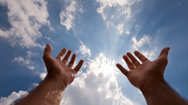 Hands reaching toward the radiant, sunlit sky